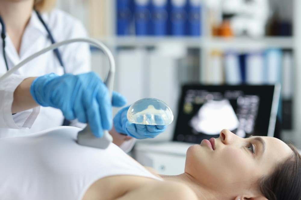 Présentation d'un radiologue effectuant une échographie à une femme ayant un implant mammaire et signe de cancer du sein