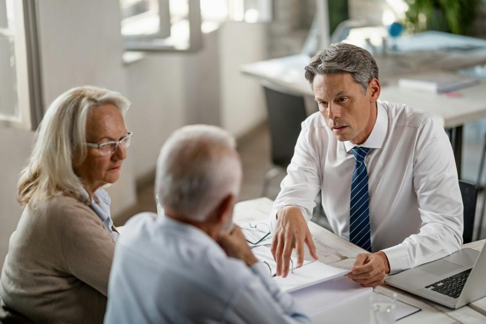 Courtier mutuelle senior en rendez-vous d'information avec un couple de seniors