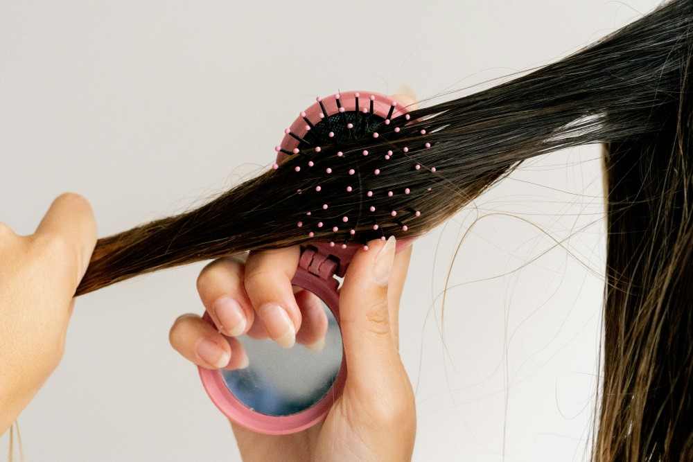 Femme qui brosse ses cheveux pellicules