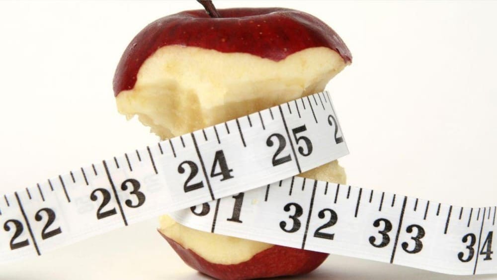 Microbiote et perte de poids, pomme entamée et mètre ruban