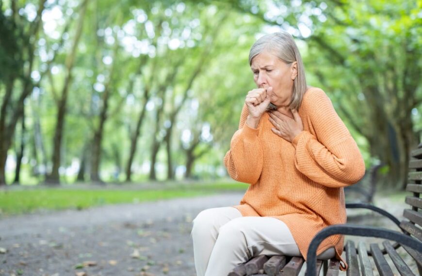 Femme sur un banc qui tousse et du mal à respirer