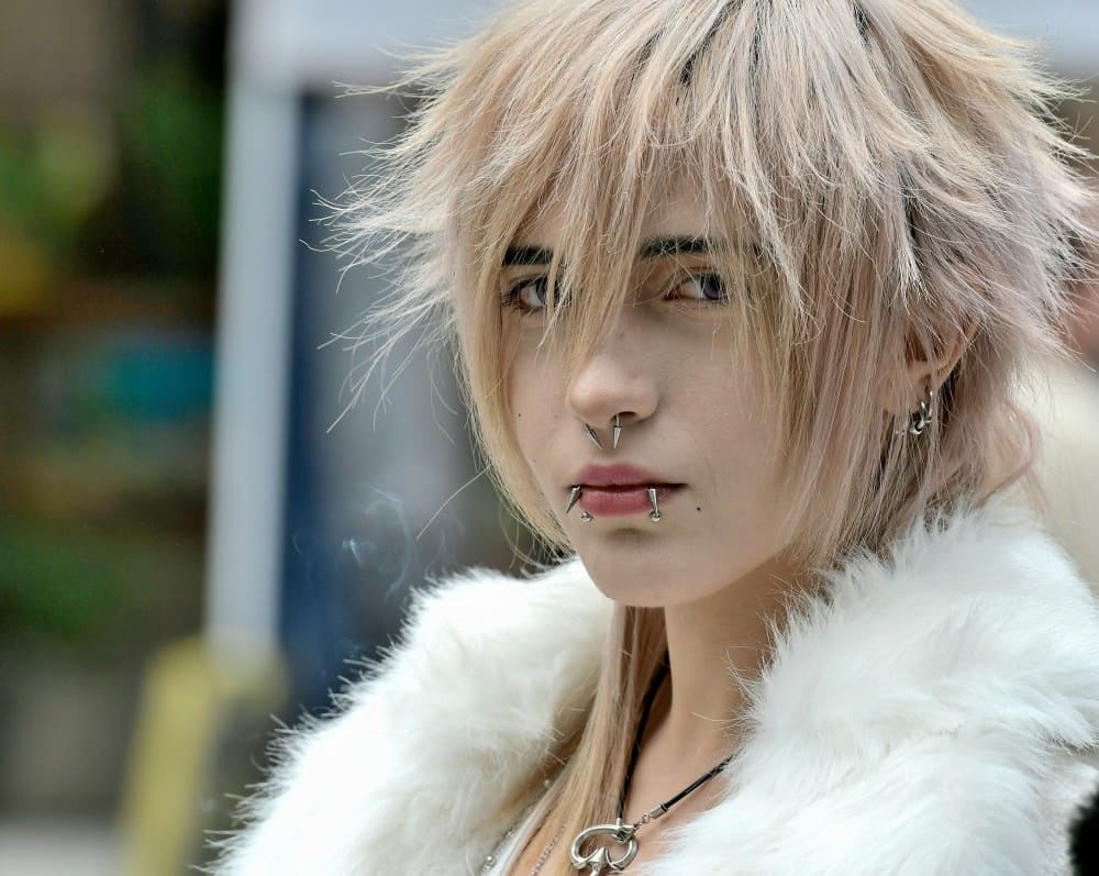 Homme ayant différents piercings medusa, labret, monroe