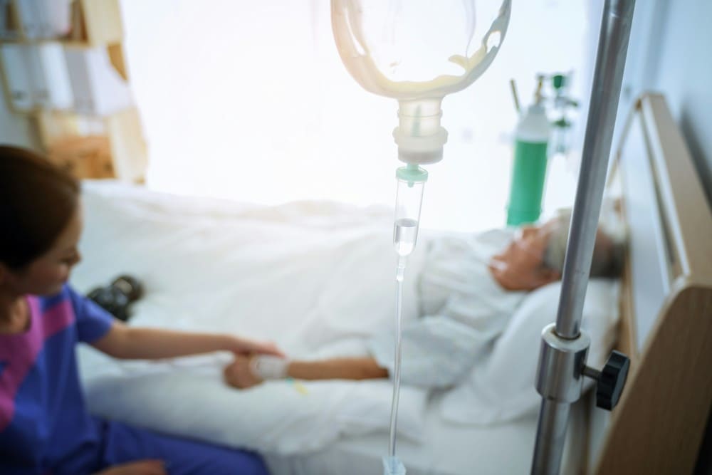 Femme dans son lit à domicile bénéficiant d'une pompe PCA