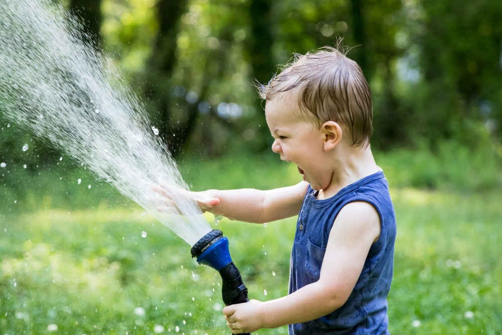 Jeune enfant qui joue avec l'eau, canicule