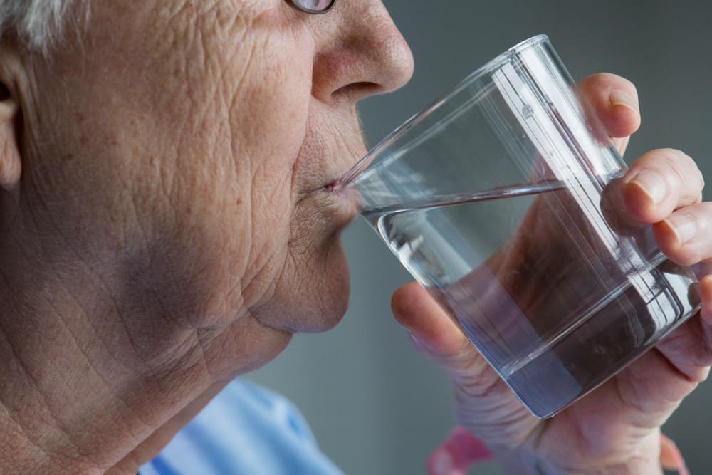 Vieille dame qui s'hydrate canicule