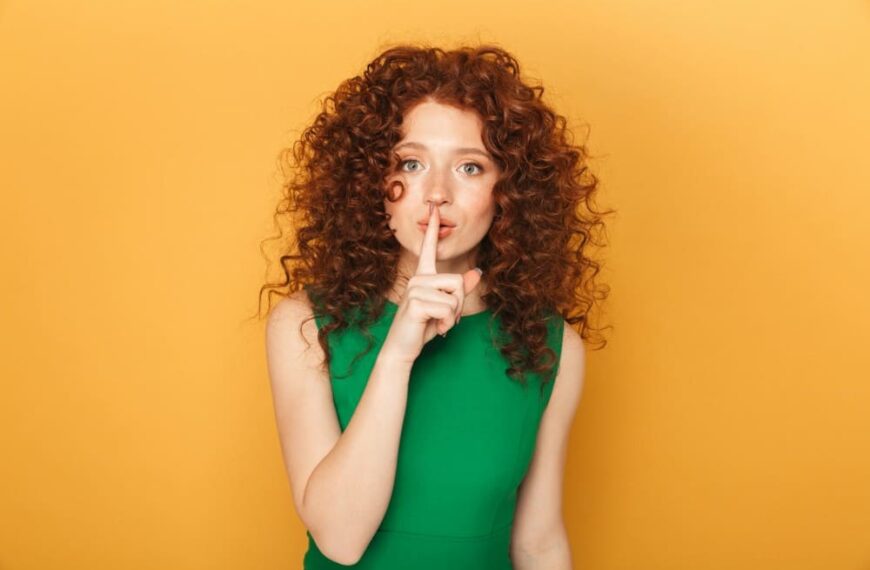 Bienfaits du silence sur le cerveau, femme aux cheveux boucles roux qui fait chut