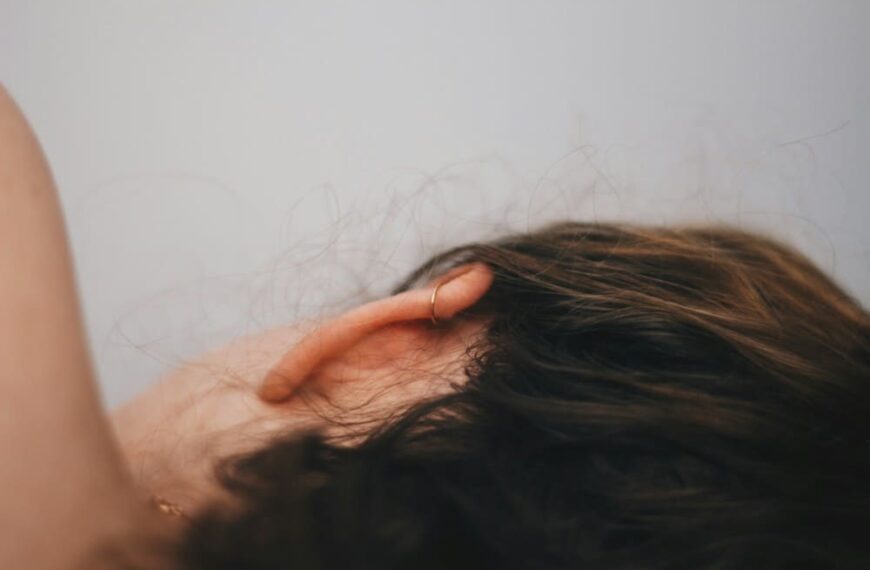 Femme allongée sur le côté montrant son oreille de dos