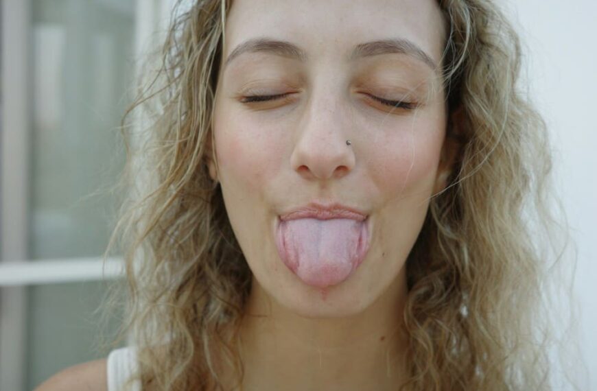 Femme aux cheveux longs ondules avec la langue blanche