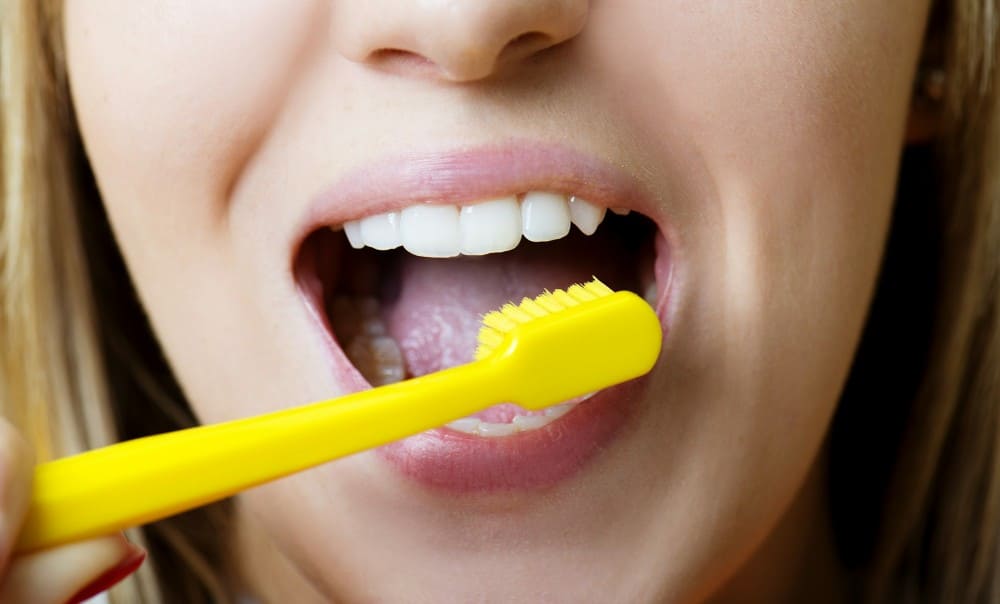 Femme qui se brosse les dents et la langue