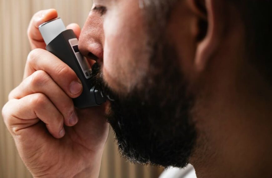 Homme barbu asthmatique qui prend de la ventoline