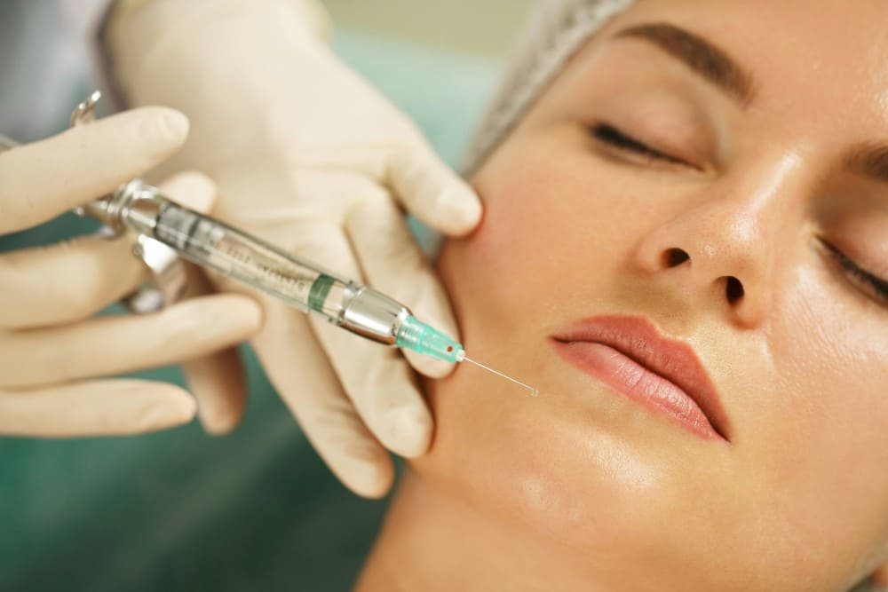 Femme recevant une injection de botox au visage avec règle asepsie obligatoire