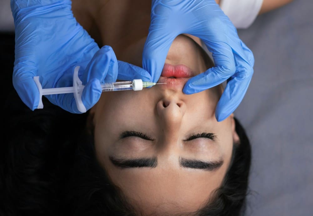 Médecin esthétique effectuant une injection de botox lèvres