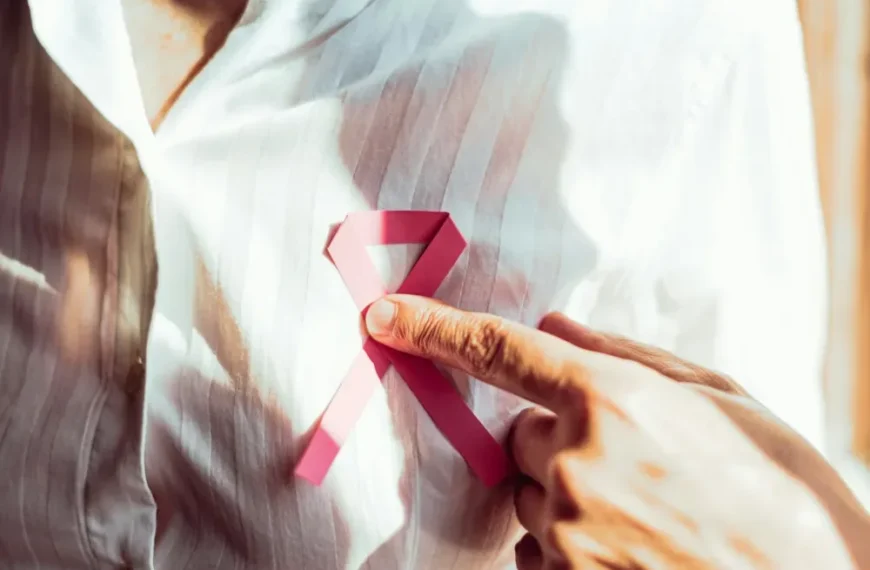Un homme porte un ruban octobre rose épinglé sur sa chemise.